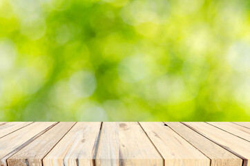 wood table top and Abstract blur green leaves background