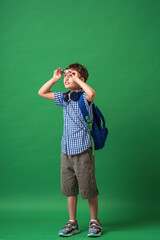 Happy cute smart boy in glasses with school bag and headphones.
