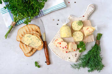 Portion of Herb Butter with pieces of sweet pepper, dill  for sandwiches and steak sliced on a wooden board. Homemade italian food.