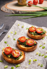 Sandwiches on toasted white bread with spinach cheese decorated with tomato slices. Selective focusing.