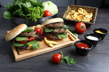 Hamburger with meat, tomatoes and potatoes. On Wooden background.