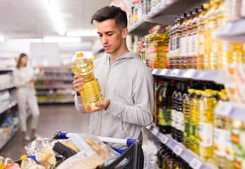 Portrait of young man choosing olive oil