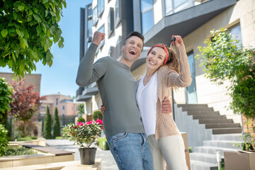 Young couple holding the keys from home and feeling excited