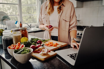 Fototapeta Young female blogger searching online browsing for recipes to prepare salad of fresh vegetables and post on social media in vlog - new hobby during isolation obraz