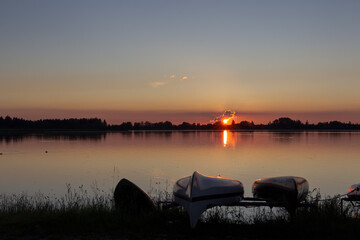 Naklejka na ściany i meble Rowing boats on the lake shore in the sunset