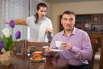 Irritated young spouses quarrelling in home interio