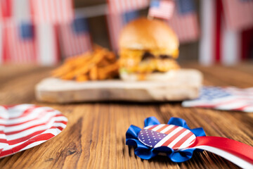 Fourth of July celebration. American flag and decorations. Burgers on rustic wooden table.