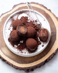 Vegetarian Chocolate Truffles With Raw Cocoa And Dates. Closeup View Of Pile Of Homemade Chocolate Truffles on white background. Chocolate Energy Balls