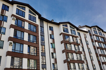 Fototapeta premium Modern apartment buildings on a sunny day with a blue sky. Facade of a modern European apartment building