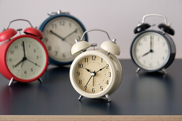 Many alarm clock with different color on dark table and white background.