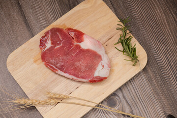 Raw beefsteak on wooden cutting board. Close up. Wooden Background