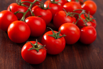Red tomatoes on wooden table in home kitchen