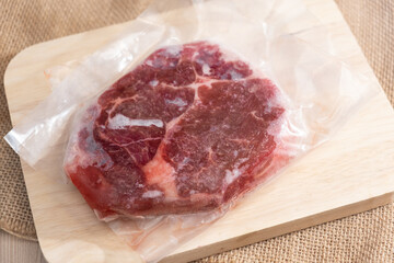 Freezing raw beef steak in the pack on a wooden background