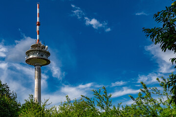A radio tower with a blue sky and a few white clouds.