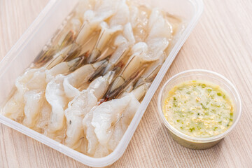 Raw shrimp in fish sauce and garlic chillies. Wooden back ground. Copy space