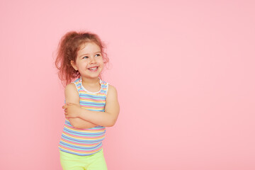 Portrait of cute little child girl with a snow-white smile and healthy teeth over pink background....