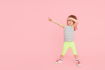 Fototapeta na wymiar Challenges for children. Child girl model in full growth on a pink studio background. empty space for inscription
