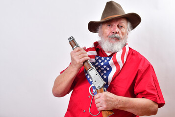 Crazy old man armed with a sawed off rifle, wearing patriotic colors, and a floppy western hat.. - obrazy, fototapety, plakaty