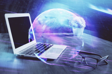 Computer on desktop in office with technology theme hologram. Multi exposure. Tech concept.