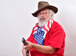 Angry old man, armed with a sawed off rifle, wearing patriotic colors, eyeglasses and a floppy western hat..Go ahead, make my day - obrazy, fototapety, plakaty