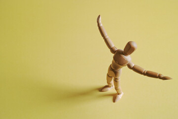 黄色背景で右寄りに立って両手を広げて喜びを表すモデル人形