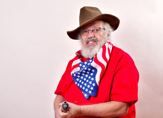 Angry old man, armed with a sawed off rifle, wearing patriotic colors, eyeglasses and a floppy western hat..Has that get off my lawn look - obrazy, fototapety, plakaty