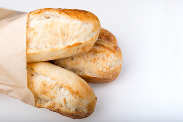 French baguettes in paper bag isolated on light background.