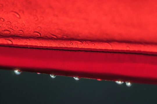 Drops of water after heavy rain on the edge of a tourist tent shine beautifully. Reflection of the landscape in the water.