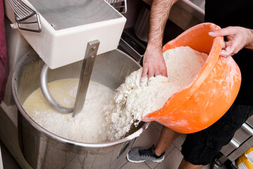 Chef adding flour to a commercial mixer