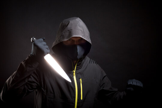 Killer in black holds the knife in aggressive style. Selective focus