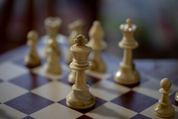 Game of Chess. Wooden chessboard with chess pieces and pawns, close up shot, shallow depth of field. Low key light