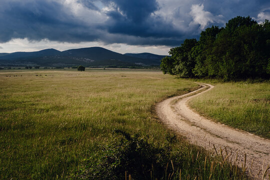 Beautiful Country Road Before A Thunderstorm At Sunset.