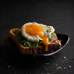 Dark photo of sandwich with fryied egg