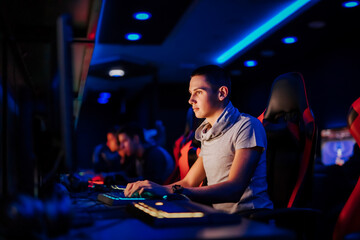 People, technology and entertainment concept. Playing video games at cybercafe, portrait.