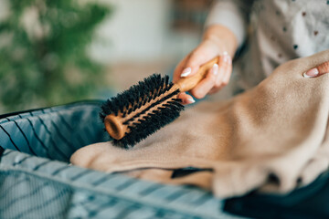 Preparing for traveling, putting hairbrush in the suitcase. People, vacation and traveling concept.