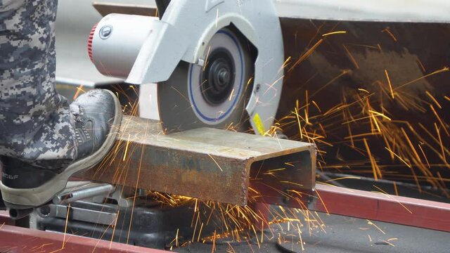 Construction worker cutting steel C-shape Channel frame with cutting circular saw machine close-up