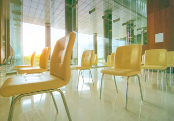 Social distancing concept. Empty yellow chair in a row with gap for social distance to prevent coronavirus (COVID-19) at waiting room in hospital for patients waiting queue. Public chair in hospital.