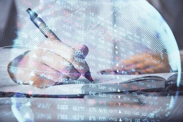 International business hologram over hands taking notes background. Concept of success. Multi exposure