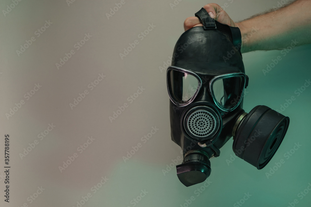 Poster Hand hold black old gas mask in the color light. Beautiful old minimal in neon light. Minimalism retro style concept. Background pattern for design.