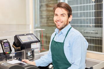 Freundlicher Kassierer an der Kasse im Supermarkt