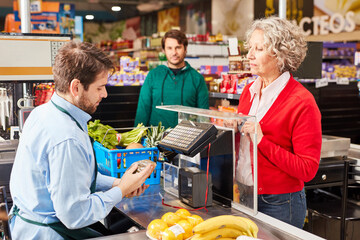 Kassierer und Kundin an der Kasse im Supermarkt