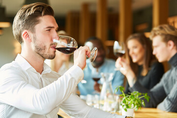 Junger Mann trinkt ein Glas Rotwein