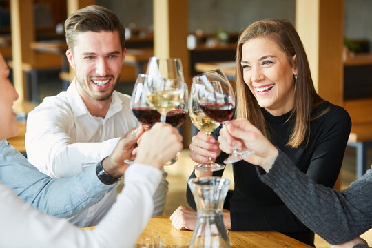 Junge Leute sto&szlig;en an mit Glas Wein