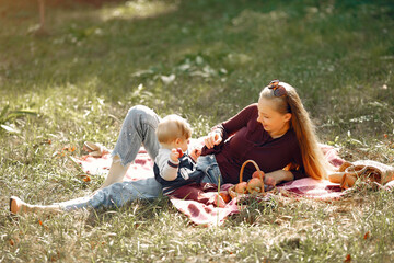 Family in a summer park. Mother in a red sweater. Cute little boy