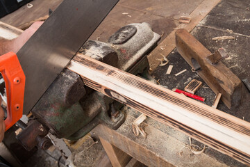 Male carpenter working on old wood in a retro vintage workshop.