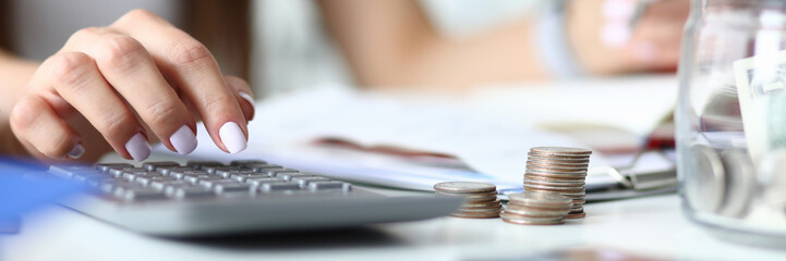 Focus on tender hands of smart businesswoman holding important paper folder. Woman calculating numbers with profits charts in comfortable workplace. Office concept. Blurred background