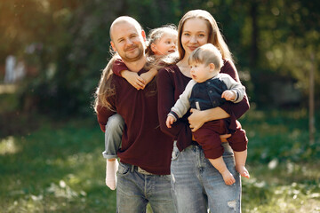 Fototapeta premium Family in a autumn park. Woman in a red sweater. Cute childrens with parents