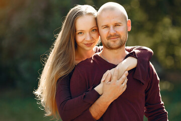 Couple in a park. Woman in a red sweater. Man with a wife