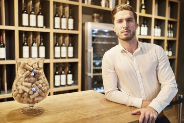 Junger Mann als Verkäufer in einer Vinothek