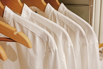 Fototapeta na wymiar 木製のハンガーにかけられた白いシャツ